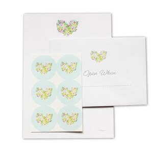 May include: A set of six floral heart-shaped stickers on a light blue background. The stickers are designed to be used on envelopes and say "Open When" on the top of the envelope.