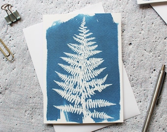 May include: A blue card with a white fern leaf printed on it. The card is blank and ready for a message.