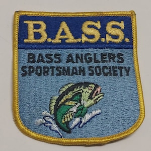May include: A blue and yellow embroidered patch with the text "B.A.S.S. Bass Anglers Sportsman Society" and a green and black bass fish jumping out of the water.