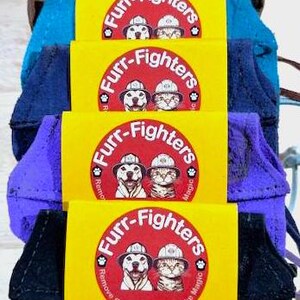 May include: A stack of five yellow and red Furr-Fighters pet hair removal tools. Each tool features a cartoon dog and cat wearing firefighter helmets. The text "Furr-Fighters" is written in a bold, black font around the cartoon animals. The bottom tool has the text "The Pocket" and "One Size Fits Most" written in black font. The text "A Travel size Pet Hair Removal Tool...when you are on the go." is written in black font.