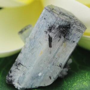 Puede incluir: Un cristal de aguamarina azul claro con inclusiones negras. El cristal es &aacute;spero y tiene un aspecto natural sin pulir.