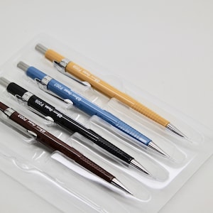 May include: Four mechanical pencils in a clear plastic pack. The pencils are brown, black, blue, and yellow. Each pencil has a silver tip and the text "0.5 mm Pentel P205" printed on the side.