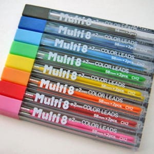 Puede incluir: Un juego de diez recambios de mina de color Multi 8 de 0,2 mm. Los recambios están envasados en tubos de plástico transparente con tapas negras. Los tubos están apilados, con el recambio rosa en la parte inferior y el recambio negro en la parte superior. Cada tubo tiene una etiqueta que dice "Multi 8 0,2 mm COLOR LEADS" y la longitud de la mina en milímetros. Las etiquetas también incluyen el número de minas en el paquete.