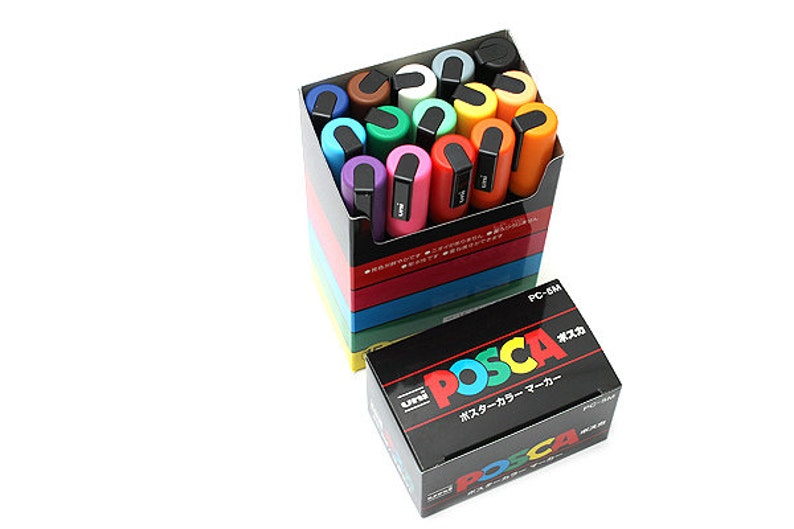 Peut inclure: Un ensemble de 16 marqueurs de peinture Uni Posca dans une vari&eacute;t&eacute; de couleurs, y compris le rouge, l'orange, le jaune, le vert, le bleu, le violet et le noir. Les marqueurs sont dans une bo&icirc;te avec le logo Uni Posca et le texte "PC-8M".