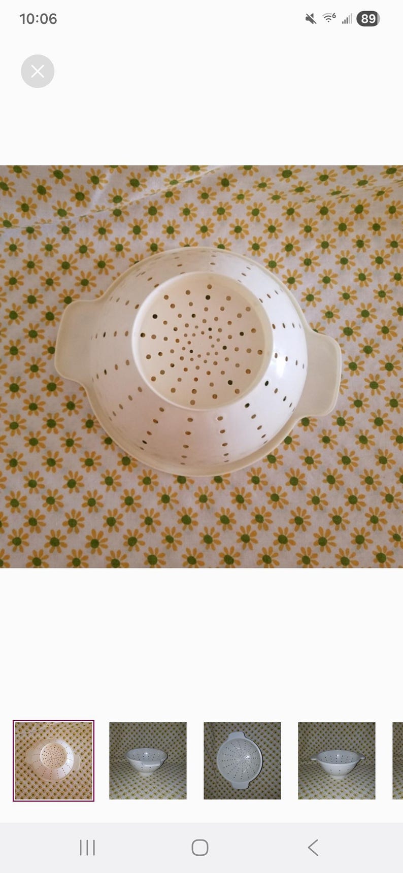 Peut inclure: Une passoire en plastique blanc avec de nombreux petits trous pour l'&eacute;gouttage. La passoire a deux poign&eacute;es et une base large. Le fond est un motif floral jaune et vert.