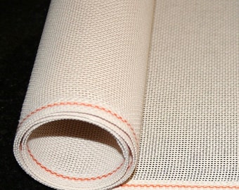 Könnte beinhalten: Aufgerolltes beiges Netzgewebe mit rotem Nahtrand. Der Stoff hat eine gewebte Textur, möglicherweise für Bastelarbeiten oder als Schutz. Das Bild zeigt eine Nahaufnahme der gerollten Kante und des offenen Gewebes.