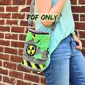 Può includere: Una borsa all'uncinetto grigia con un simbolo di pericolo nero e giallo e dettagli. La borsa ha un design verde strutturato e una tracolla grigia. Il testo "PDF ONLY" è visibile nell'immagine.