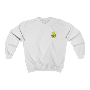 May include: White sweatshirt with a small avocado design on the front. The avocado is green with a brown pit and a smiling face.