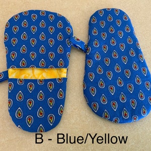 May include: A pair of blue oven mitts with a yellow and white paisley pattern. The mitts have a hanging loop and a pocket on the back. The text "B - Blue/Yellow" is printed below the mitts.