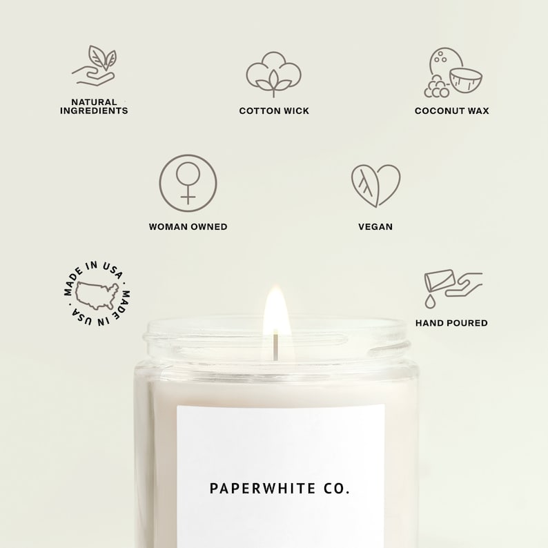 May include: A white candle in a clear glass jar with a white label that reads "PAPERWHITE CO.". The candle is made with natural ingredients, coconut wax, and a cotton wick. It is hand-poured and vegan.