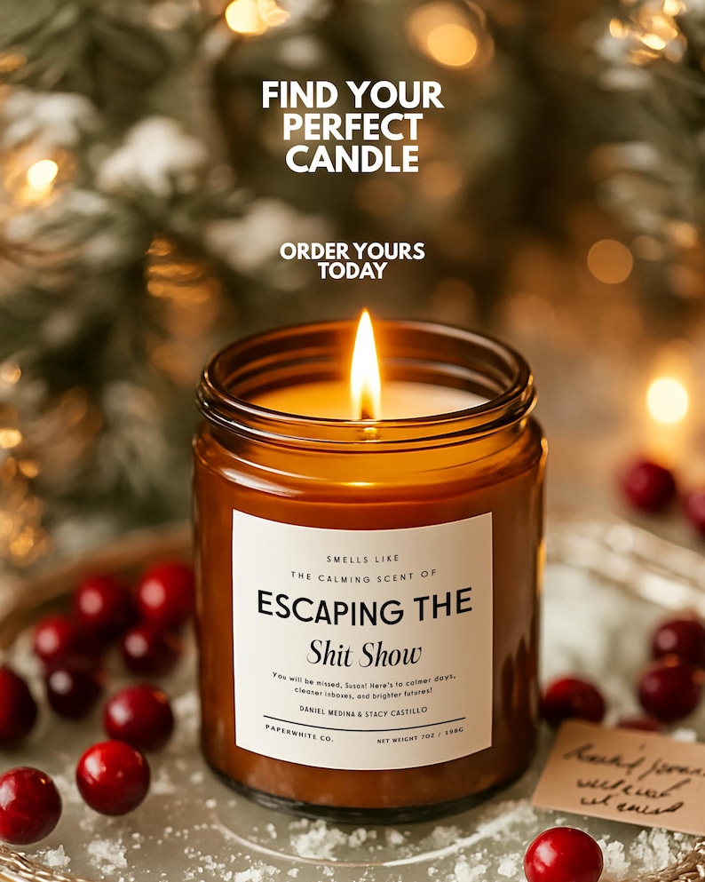 May include: A lit candle in an amber glass jar with a white label reading "SMELLS LIKE THE CALMING SCENT OF ESCAPING THE Shit Show". The label includes additional text and "NET WEIGHT 7OZ / 198G". The candle is surrounded by red cranberries.