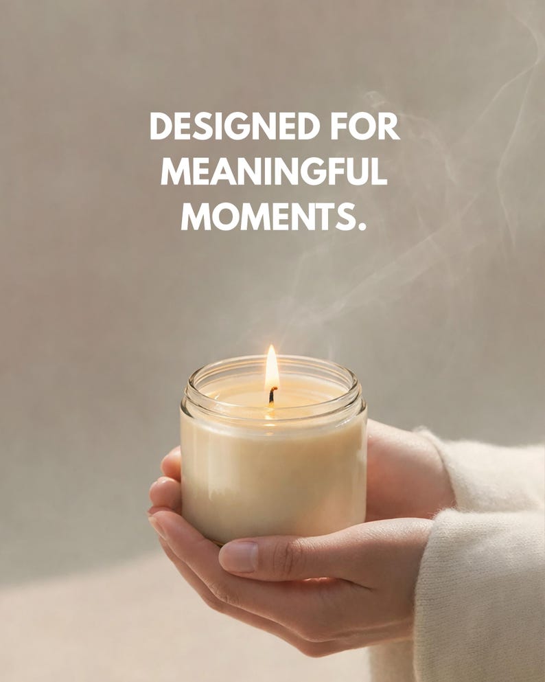 May include: A lit candle in a clear glass jar is held in cupped hands. The candle has a soft, creamy color, and the flame is bright. The text "DESIGNED FOR MEANINGFUL MOMENTS" is above the candle.