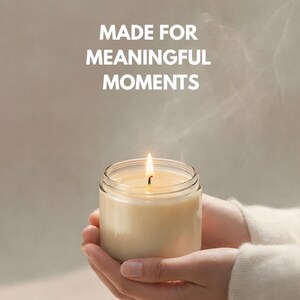 May include: A lit candle in a clear glass jar, held gently in cupped hands. The candle's flame glows brightly, with the text "MADE FOR MEANINGFUL MOMENTS" in white above the candle.