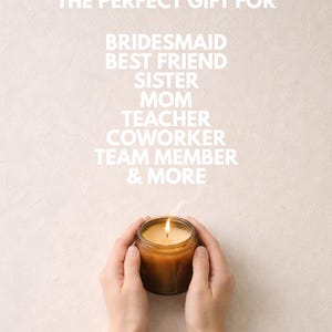 May include: A lit candle in a brown glass jar with white text above reading THE PERFECT GIFT FOR BRIDESMAID BEST FRIEND SISTER MOM TEACHER COWORKER TEAM MEMBER & MORE. The candle emits a thin wisp of smoke from the flame against a light background.