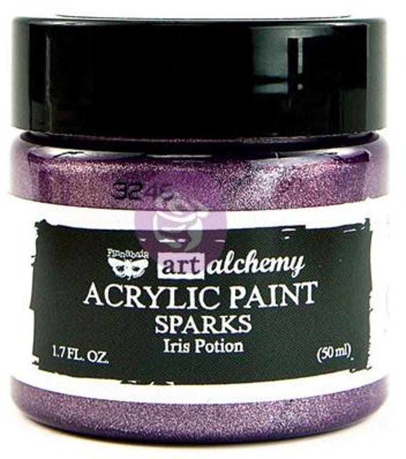 May include: A jar of Finnabair Art Alchemy Sparks acrylic paint in the colour Iris Potion. The jar has a black screw-top lid and a label with white text reading Art Alchemy, Acrylic Paint, Sparks, Iris Potion, 1.7 fl. oz., and 50 ml.