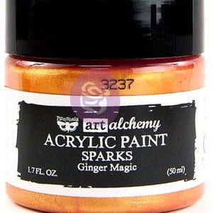 May include: A jar of Art Alchemy Sparks acrylic paint in the colour Ginger Magic. The jar has a black lid and a label with the text 3237, Finnabair, art alchemy, ACRYLIC PAINT, SPARKS, Ginger Magic, 1.7 FL. OZ., and 50 ml. The paint is orange.