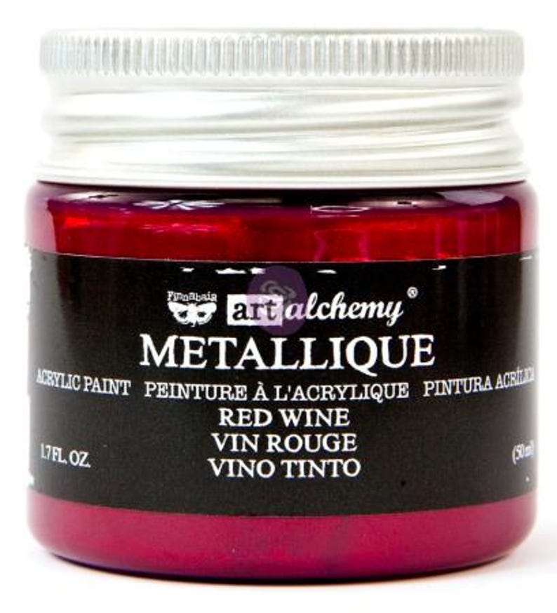 May include: A small glass jar of Finnabair Art Alchemy Metallique acrylic paint in the colour Red Wine. The jar features a silver screw-top lid and a black label with white text reading Metallique, Red Wine, 1.7 fl. oz. and 50 ml.