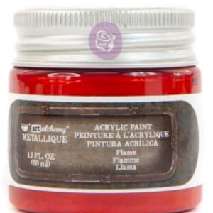 May include: A small jar of Art Alchemy Metallique acrylic paint in the colour Flame. The jar has a silver screw-top lid and a label that reads 1.7 fl. oz. (50 ml). The paint inside is a vibrant red colour, and the label features a dark brown border.