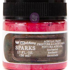 May include: A small jar of bright pink acrylic paint with a black ribbed screw-top lid. The label features the text Art Alchemy Sparks, 50 ml (1.7 fl. oz.), and the colour name Enchanted. The container is cylindrical with a clear glass base.