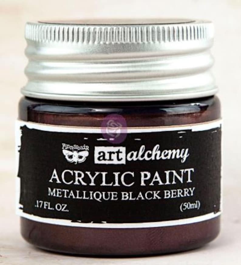 May include: A small jar of Finnabair Art Alchemy acrylic paint in the colour Metallique Black Berry. The jar features a silver screw-top lid and a black label with white text reading Art Alchemy, Acrylic Paint, Metallique Black Berry, 50ml.