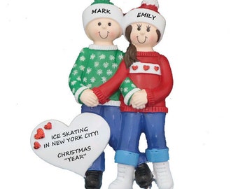 May include: Personalized Christmas ornament featuring a couple ice skating, wearing winter hats and sweaters. The ornament includes the names "Mark" and "Emily" and the text "Ice Skating in New York City! Christmas "Year""
