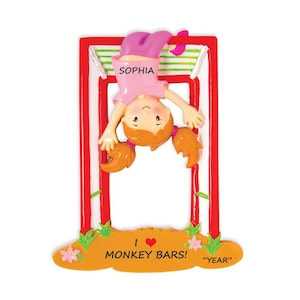May include: A personalized Christmas ornament featuring a girl hanging upside down on monkey bars. The ornament is red, white, and green with the girl's name "Sophia" and the text "I love monkey bars!" The ornament also includes a space for the year.