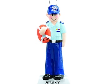 May include: A blue and white personalized Christmas ornament depicting a person wearing a blue uniform and a blue cap with a gold emblem. The person is holding a red life preserver with the word "YEAR" written on it. The ornament has a white base with the name "JEREMY" written on it.