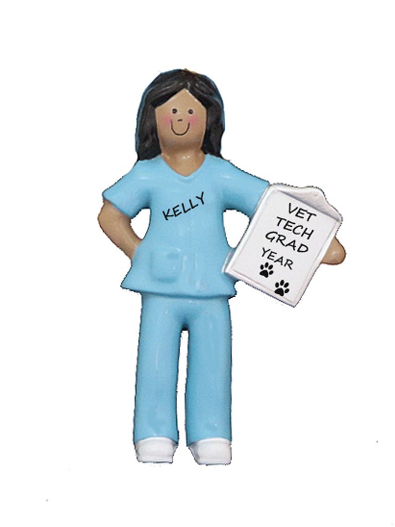 May include: A blue and white ornament of a female veterinary technician holding a clipboard that says "Vet Tech Grad Year" with paw prints. The ornament has the name "Kelly" on the shirt.