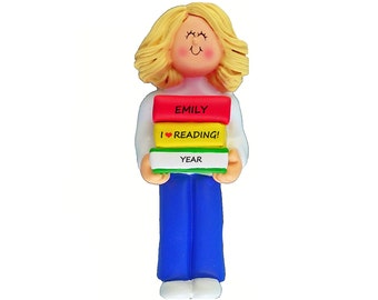 May include: A personalized teacher ornament with a blonde woman holding a stack of books. The books are labeled "Emily", "I ♥ Reading!" and "Year".