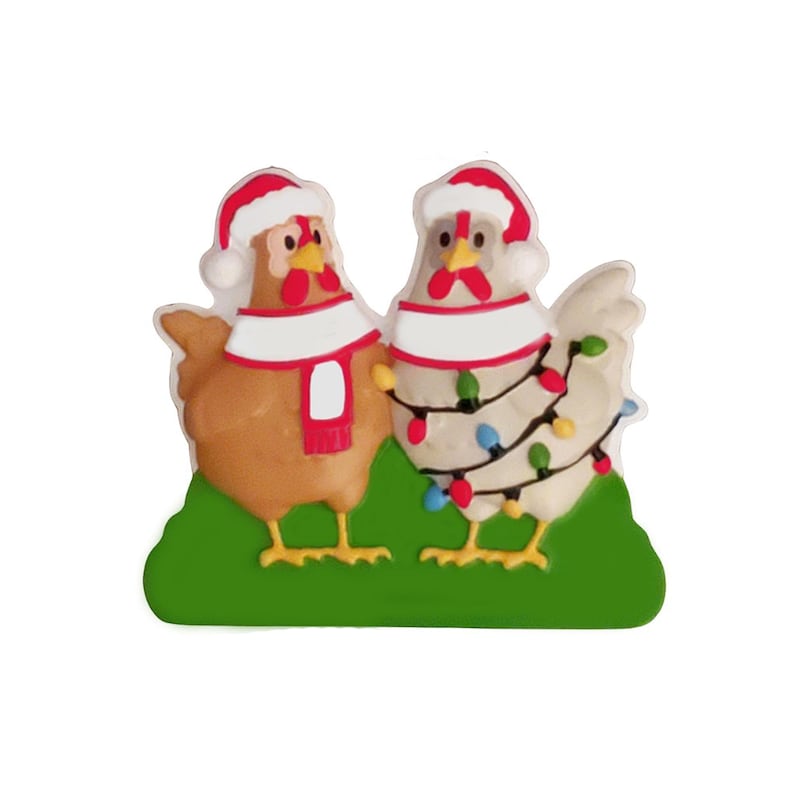 May include: A whimsical Christmas decoration featuring two chicken figures. One is brown, the other white, both wearing Santa hats and scarves. The white chicken is adorned with colorful string lights, all standing on a green base.