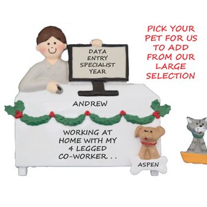 May include: A white Christmas ornament depicting a person sitting at a desk with a computer, a garland, and a dog and cat. The text on the ornament reads "DATA ENTRY SPECIALIST YEAR", "ANDREW", "WORKING AT HOME WITH MY 4 LEGGED CO-WORKER...", and "ASPEN".
