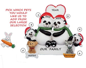 May include: A family ornament featuring panda bears wearing Santa hats and scarves, with the words "Dad" and "Mom" on their hats. The ornament includes a heart with the word "Year" and has additional panda bear children, a dog named Aspen, a cat named Patches, and a bunny.