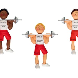 May include: Three personalized ornaments of people lifting weights. The ornaments are white, red, and silver. The people have different hair colors and skin tones. The ornaments have the names "Anthony", "Steve", and "Ryan" on them.