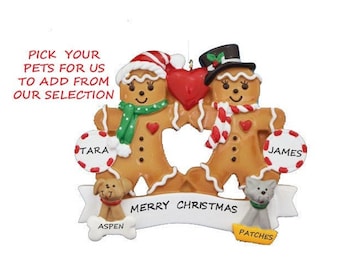 May include: Gingerbread couple Christmas ornament with a red heart, holding hands. The ornament has a banner that says "Merry Christmas". The gingerbread people are named Tara and James. The ornament also includes two pets, a dog named Aspen and a cat named Patches.