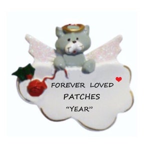 May include: A white ceramic angel ornament with a gray cat sitting on a cloud. The cat has a halo and wings. The cloud has the text "FOREVER LOVED PATCHES "YEAR" written on it.