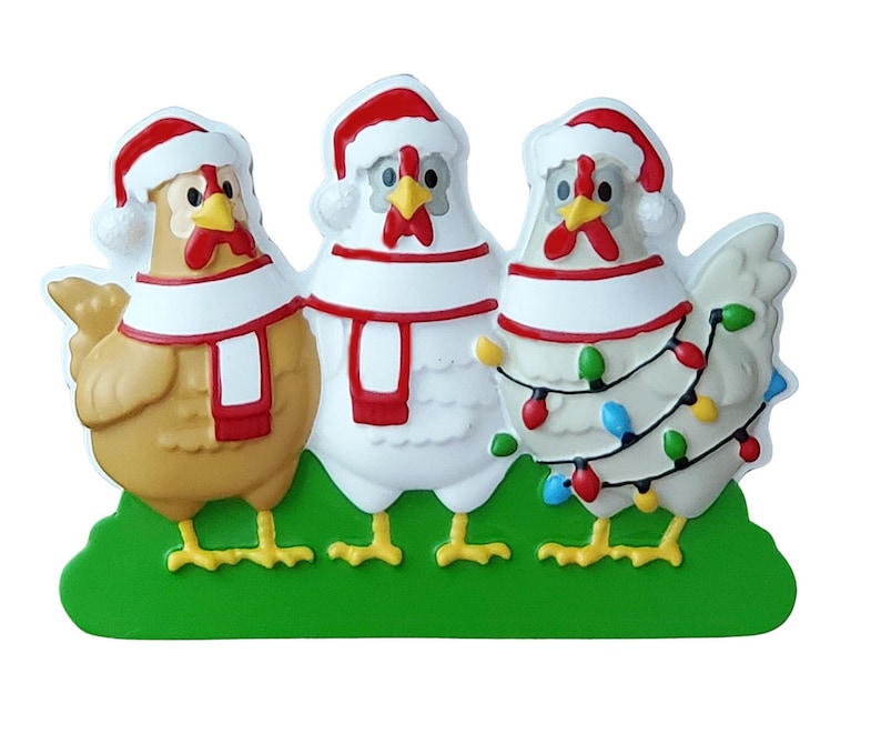May include: A decorative Christmas ornament featuring three chickens wearing Santa hats and scarves. The chickens are in shades of brown and white, with red and white accents. One chicken is adorned with colorful Christmas lights, all standing on a green base.