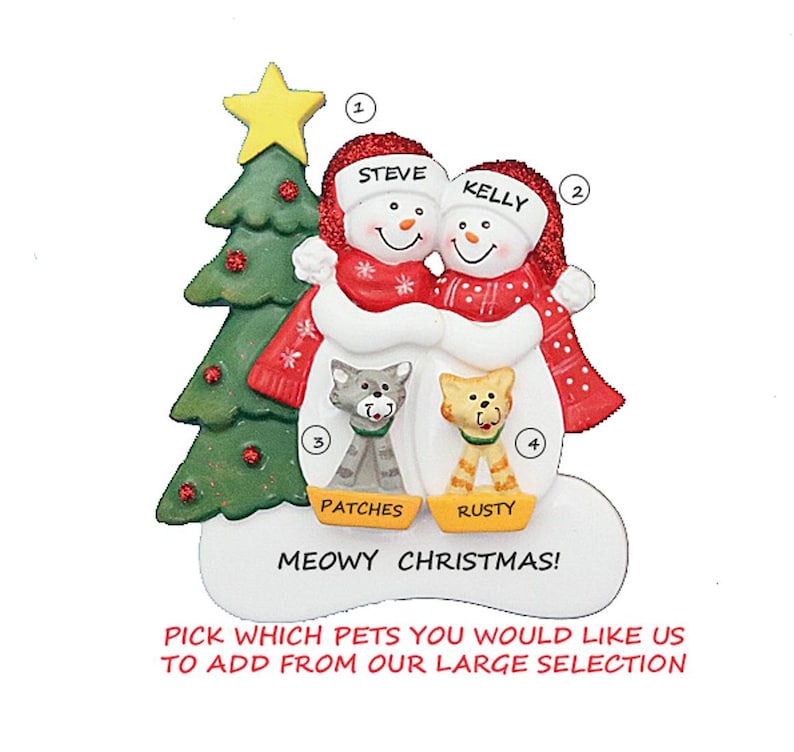 Op de afbeelding: Een kerstornament met twee sneeuwmannen met de namen "Steve" en "Kelly" op hun hoeden, die elkaar omarmen. Een groene kerstboom en twee katten genaamd "Patches" en "Rusty" zijn ook te zien. Het ornament luidt "Meowy Christmas!"