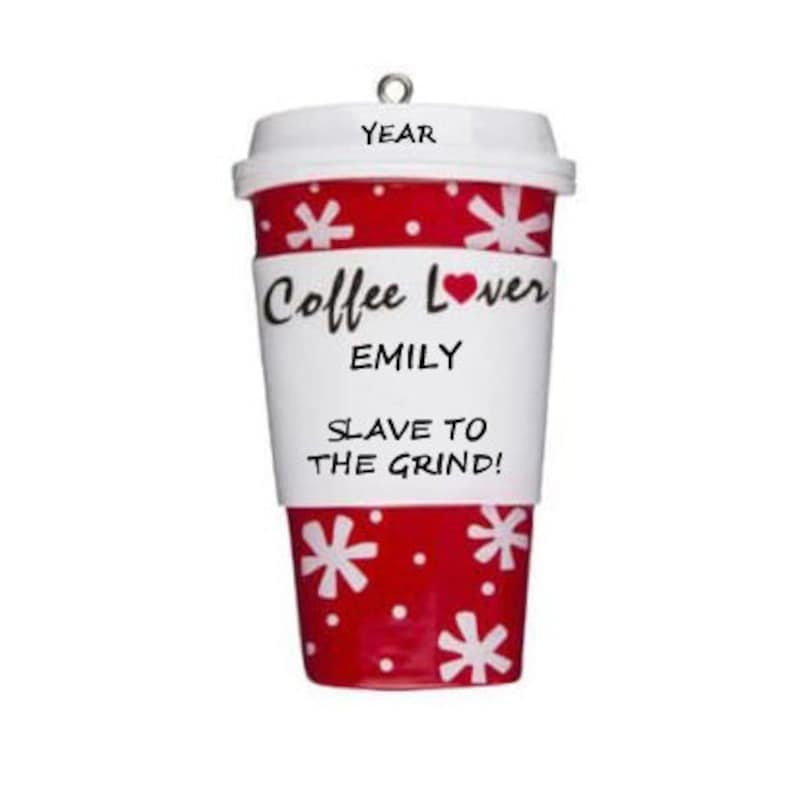 Op de afbeelding: Een koffiebeker ornament met een wit deksel en een rode body versierd met witte sneeuwvlokken. De beker heeft een witte band met de tekst "Coffee Lover" en "EMILY", en "SLAVE TO THE GRIND!". Bovenop zit een kleine metalen lus.