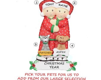 May include: Personalized Christmas ornament featuring a couple in red pajamas with their pets. The ornament has the names "Tony" and "Katie" and the pets' names "Patches" and "Aspen". The ornament also includes the text "Christmas Year".