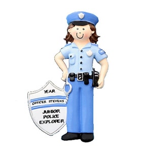 May include: A blue and white police officer ornament with a shield that says "Year Officer Stevens Junior Police Explorer".
