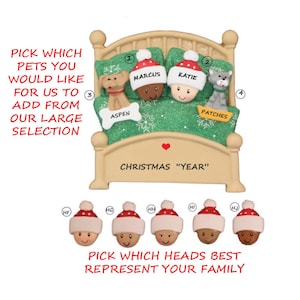 May include: A personalized Christmas ornament featuring a bed with two people and two pets. The ornament is decorated with snowflakes and a heart. The text "Christmas "Year"" is printed on the bed.  The ornament also includes a selection of different head options to choose from.