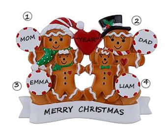 Puede incluir: Adorno navideño de familia de jengibre con detalles rojos, blancos y verdes. El adorno presenta una mamá, un papá, un hijo y una hija de jengibre sosteniendo bastones de caramelo y un corazón que dice "YEAR". La pancarta en la parte inferior dice "Feliz Navidad".