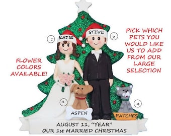 May include: Personalized Christmas ornament featuring a bride and groom in front of a green glitter Christmas tree. The ornament includes the couple's names, "Katie" and "Steve", and the date "August 11, "Year" Our 1st Married Christmas". The ornament also includes two pets, a dog named "Aspen" and a cat named "Patches".