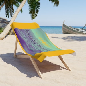 May include: A yellow beach chair with a beach towel featuring a purple and green design with the text "Eat, seen,  &  disappear" and the words "Sailing for eternity".
