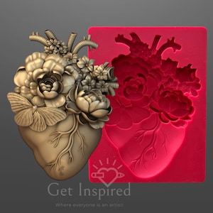 Puede incluir: Una escultura dorada en forma de corazón adornada con flores y una mariposa, junto a un molde rojo del mismo diseño. La escultura tiene detalles intrincados, incluyendo venas y arreglos florales. El texto "Get Inspired" está en la parte inferior.