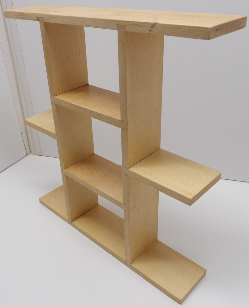 Puede incluir: Una estanter&iacute;a de pared de madera clara con cuatro estantes. La estanter&iacute;a est&aacute; hecha de madera sin tratar y tiene un dise&ntilde;o sencillo.