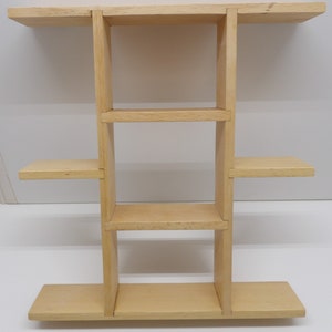 Puede incluir: Una estanter&iacute;a de pared de madera con cuatro estantes. La estanter&iacute;a est&aacute; hecha de madera clara y tiene un dise&ntilde;o sencillo.