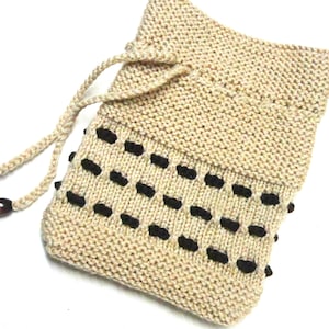May include: A beige knitted drawstring bag with black accents. The bag has a simple design and is perfect for carrying small items.