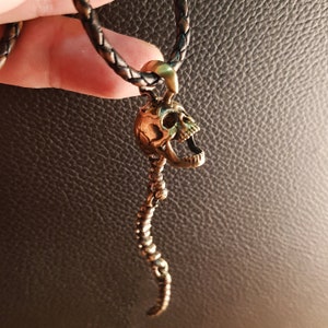 Skull Skeleton pendant with spine with 4 moving parts.