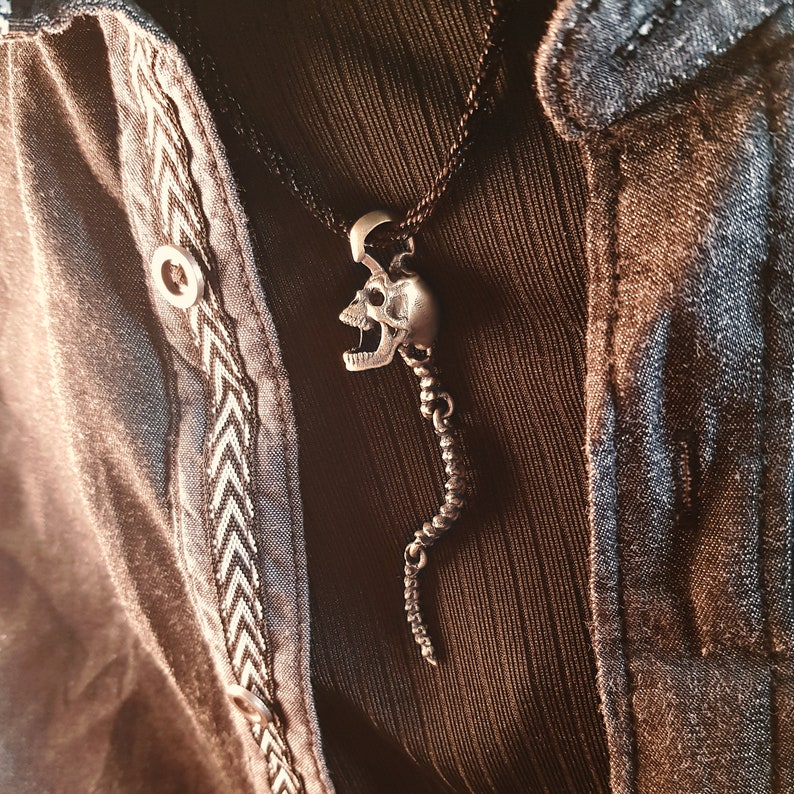 Skull Skeleton pendant with spine with 4 moving parts.